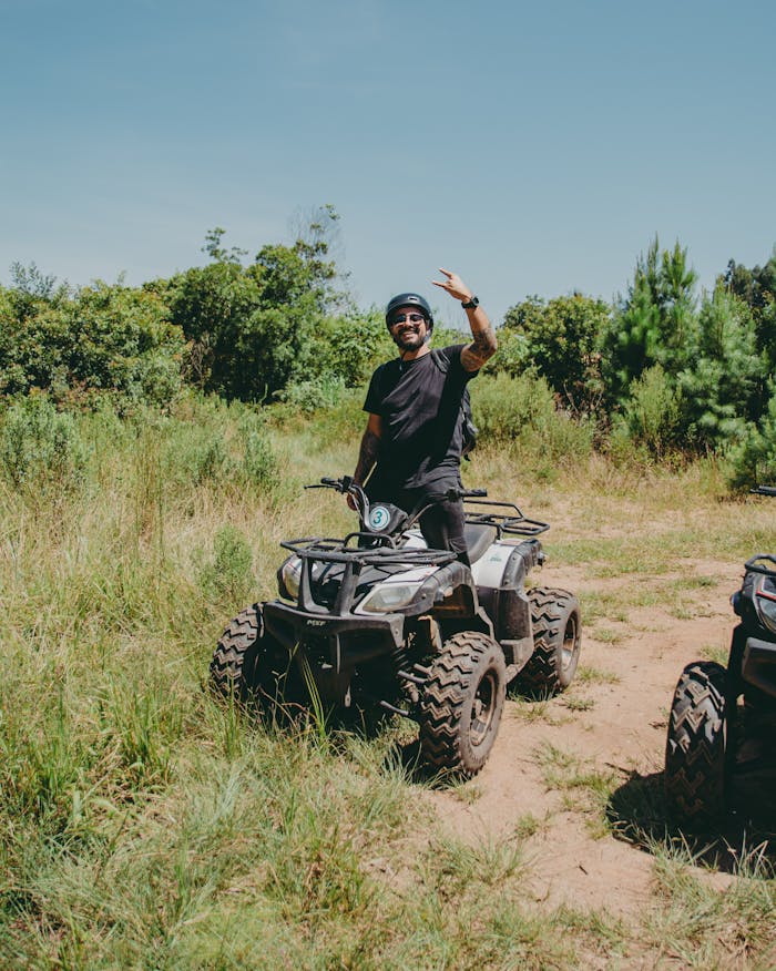gallery-6 A man enjoying an ATV ride through lush greenery in Quatro Barras, Brazil, on a sunny day.
