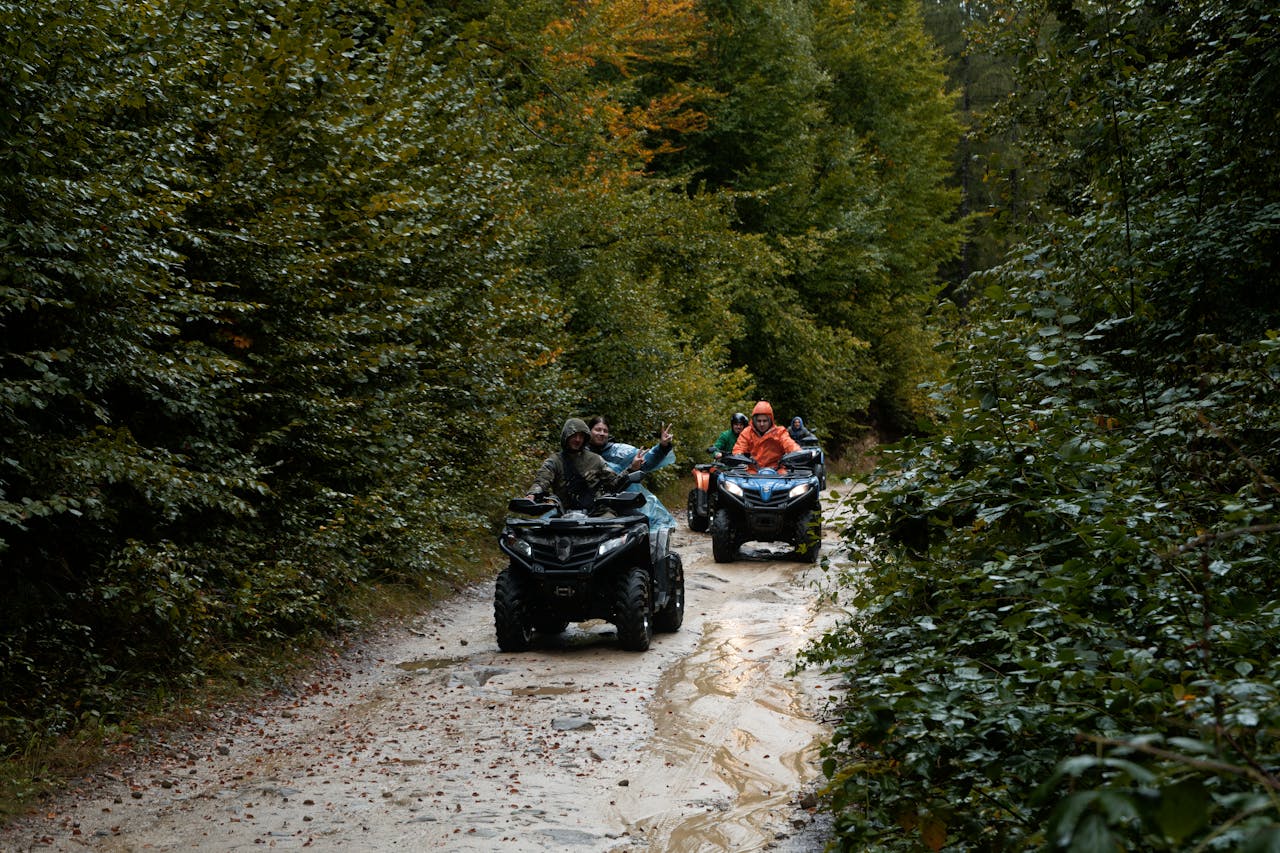 gallery-4 Group enjoying an adventurous ATV ride through a lush forest trail, exploring nature.