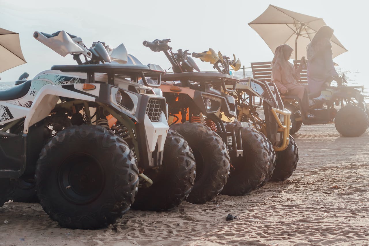 ATVs lined up in the desert with riders enjoying an offroad adventure under umbrellas.